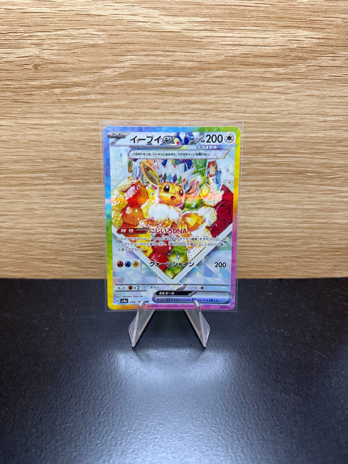 Japanese Eevee ex Pokémon card displayed on a stand