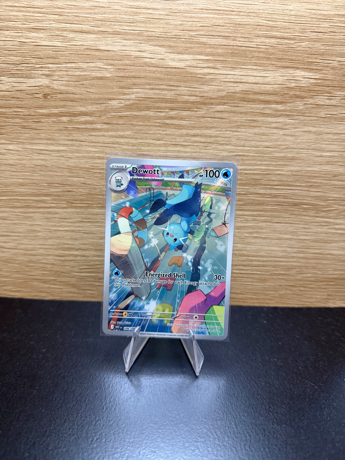 English Dewott Pokémon card displayed on a stand